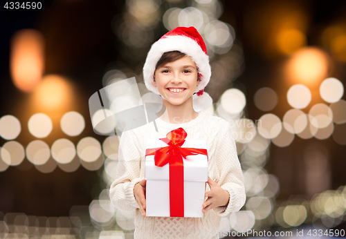 Image of smiling happy boy in santa hat with christmas gift