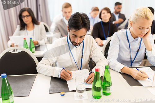 Image of businesspeople with papers at conference