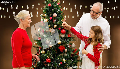Image of happy family decorating christmas tree