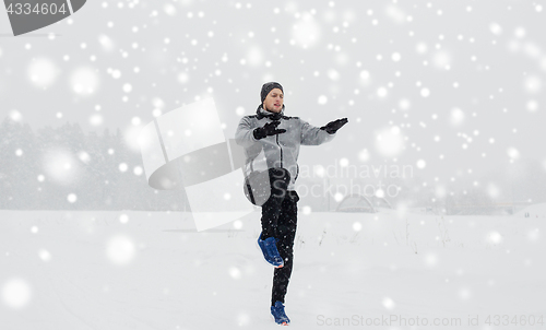 Image of man exercising and warmig up in winter outdoors