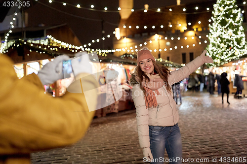 Image of happy woman posing for smartphone at christmas