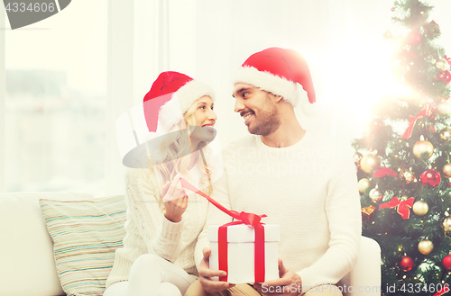 Image of happy couple at home with christmas gift box
