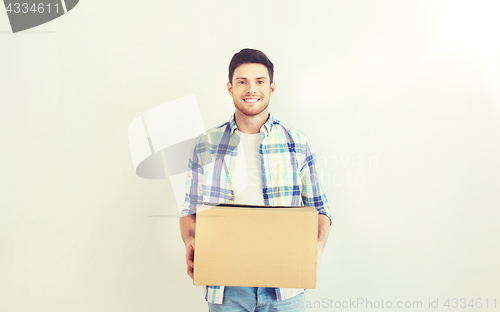 Image of smiling young man with cardboard box at home