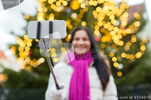 Image of woman taking selfie with smartphone at christmas 