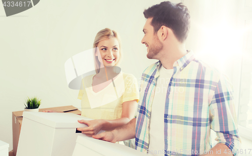 Image of smiling couple with big boxes moving to new home