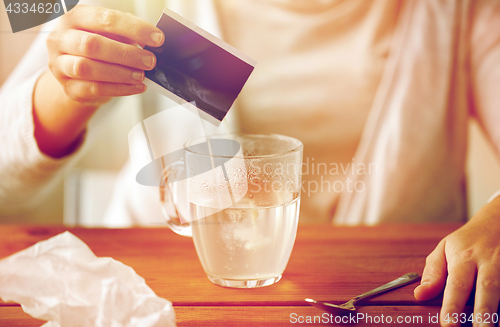 Image of woman pouring medication into cup of water