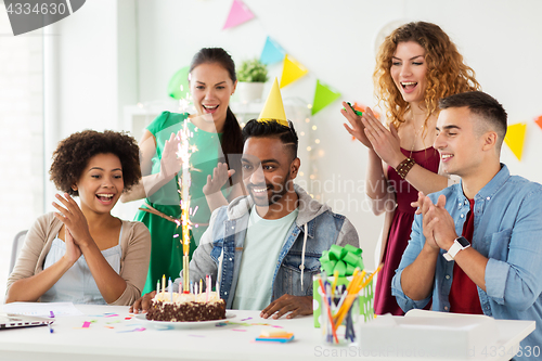 Image of team greeting colleague at office birthday party