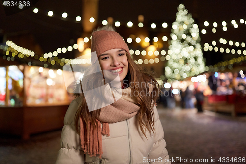 Image of happy young woman at christmas market in winter