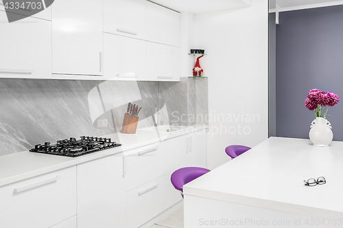 Image of modern kitchen with dining table and purple chairs