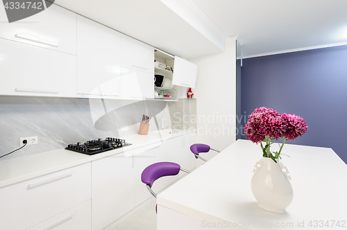 Image of modern kitchen with dining table and purple chairs