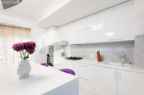 Image of modern kitchen with dining table and purple chairs
