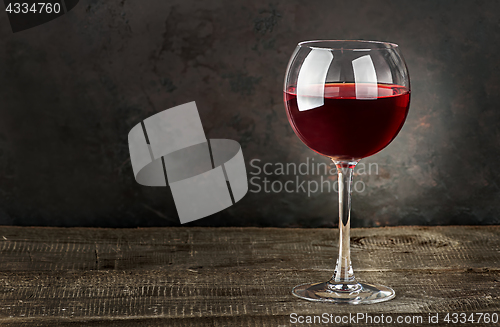 Image of Glass of red wine on a wooden table