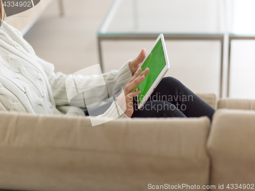 Image of asian woman using Digital Tablet on sofa