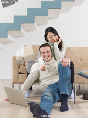 Image of happy multiethnic couple relaxing at home