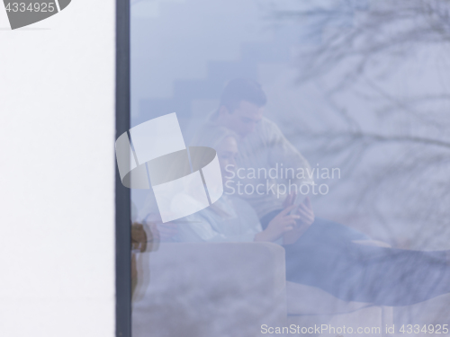 Image of Couple using digital tablet on cold winter day