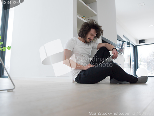 Image of young man using a tablet at home