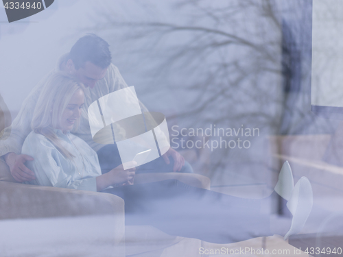 Image of Couple using digital tablet on cold winter day