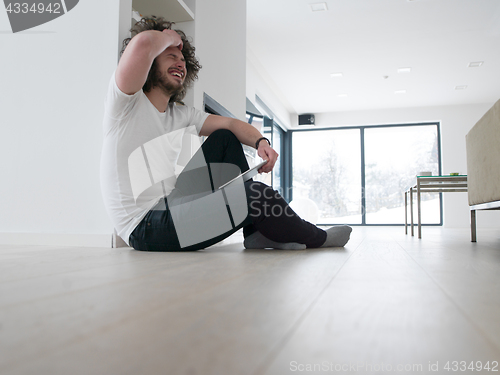 Image of young man using a tablet at home