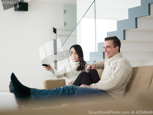 Image of multiethnic couple on the sofa watching television