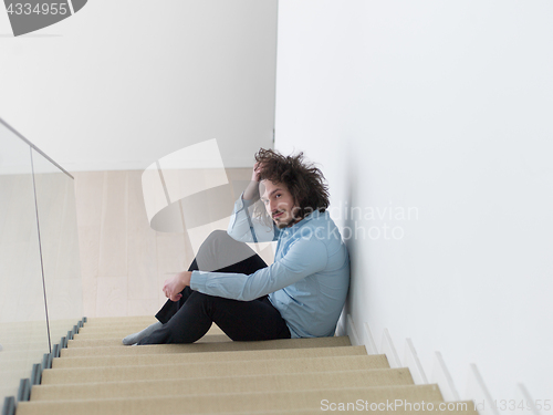 Image of young man sitting on the stairs