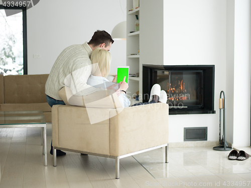 Image of Couple using digital tablet on cold winter day