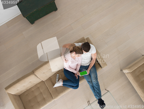 Image of couple on sofa using tablet computer top view