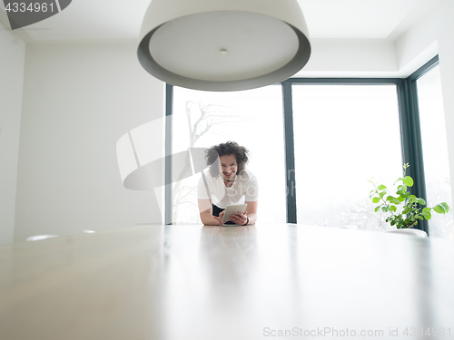 Image of young man using a tablet at home