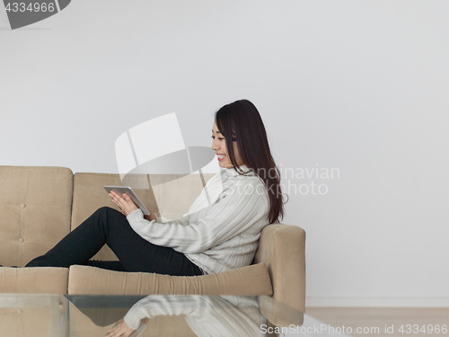 Image of asian woman using Digital Tablet on sofa