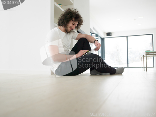 Image of young man using a tablet at home