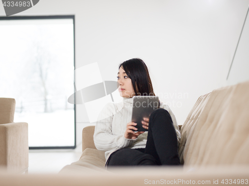Image of asian woman using Digital Tablet on sofa