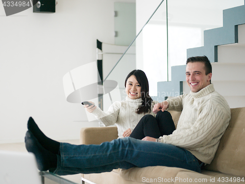 Image of multiethnic couple on the sofa watching television