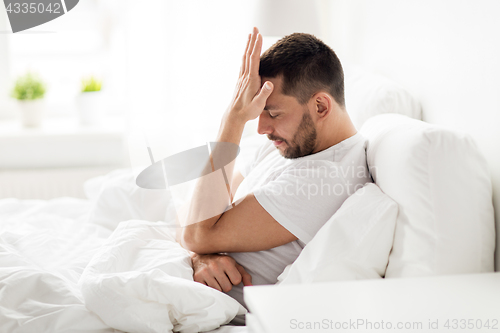 Image of stressed man in bed at home