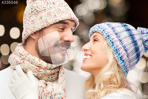 Image of happy couple hugging over christmas lights