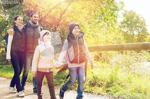 Image of happy family with backpacks hiking in woods