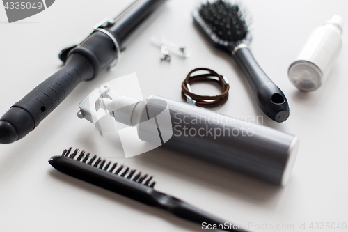 Image of styling spay, brushes, hair ties and curling iron