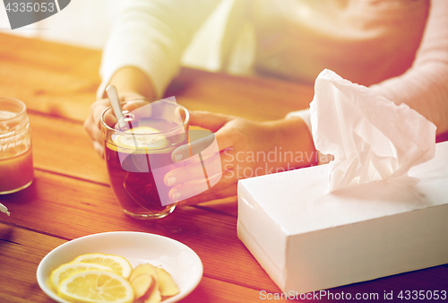 Image of close up of ill woman drinking tea with lemon