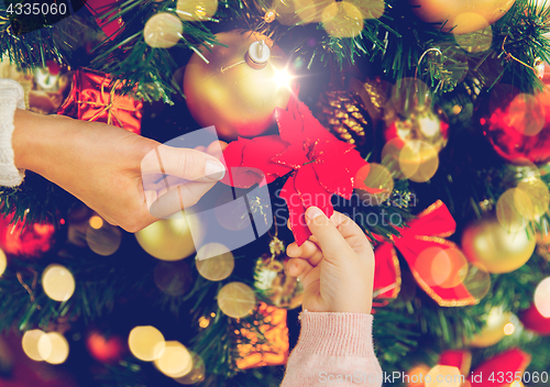 Image of close up of family decorating christmas tree