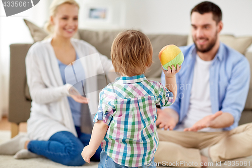 Image of happy family playing with ball at home
