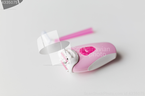 Image of epilator and safety razor on white background