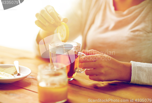 Image of close up of ill woman drinking tea with lemon