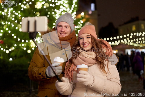 Image of couple with coffee taking selfie at christmas