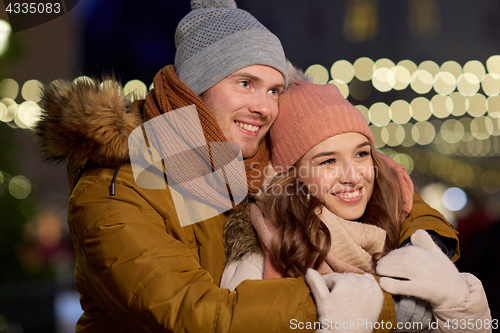 Image of happy couple hugging at christmas tree