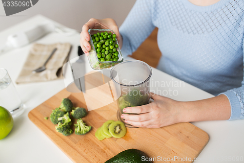 Image of woman hand adding pea to measuring cup