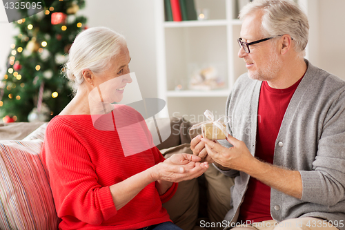 Image of happy smiling senior couple with christmas gift