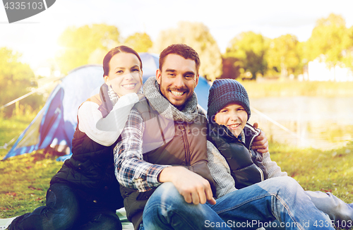 Image of happy family with tent at camp site