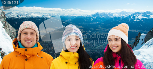 Image of happy friends in winter over alps mountains