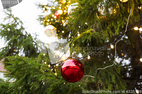 Image of close up of fir with christmas tree toys outdoors