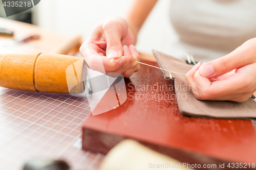 Image of Leather handbag craftsman at work in a workshop