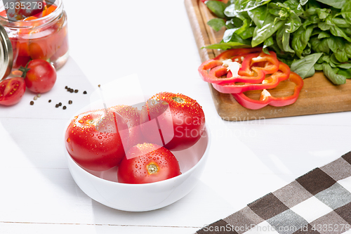 Image of Canned tomatoes and fresh tomato on white background