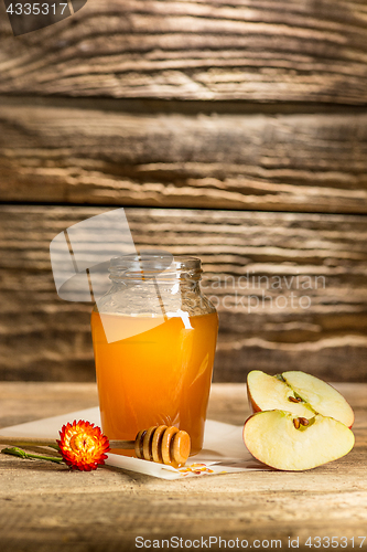 Image of The bowl with honey on wooden table.The bank of honey stay near wooden spoon